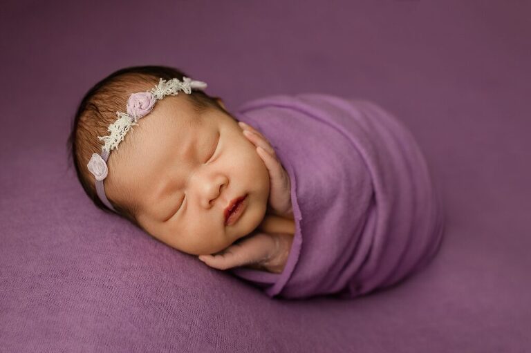 baby wrapped in purple with headband